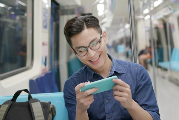 man watching phone on a train