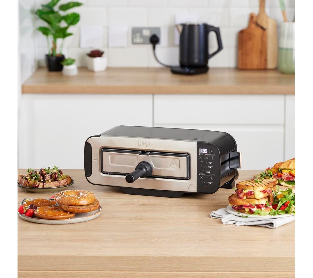 a toaster oven on a wooden counter with food on it