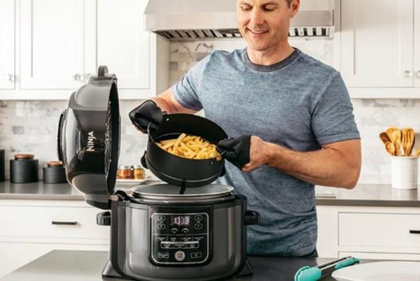 man using ninja multi pressure cooker and air fryer