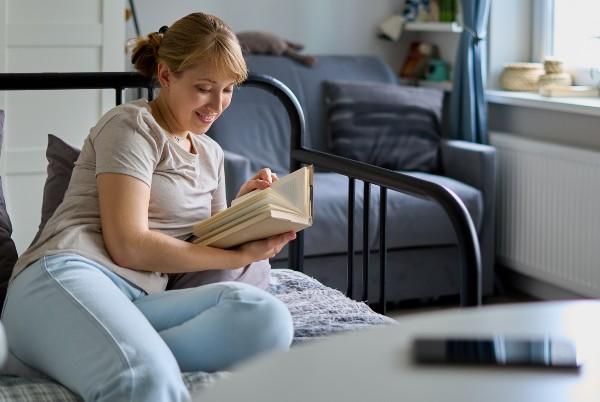 woman reading a book away from the phone