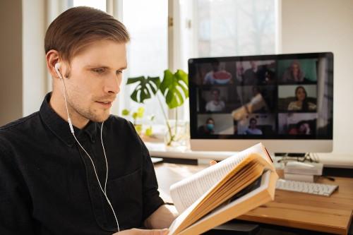 man reads book at the computer