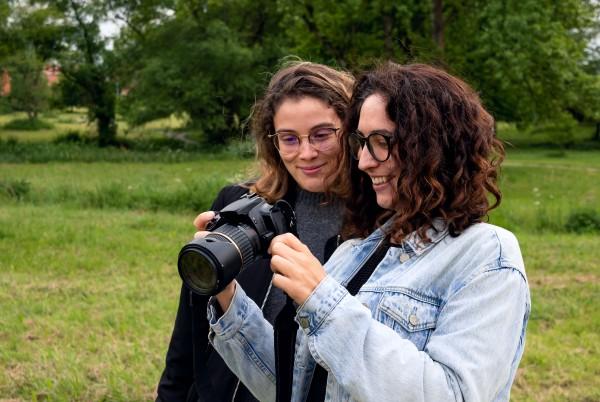 two women looking at photos in a dslr camera
