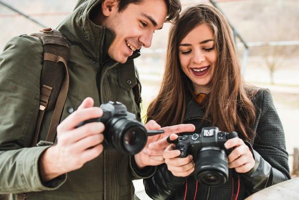 couple using mirrorless csc cameras and looking at photos