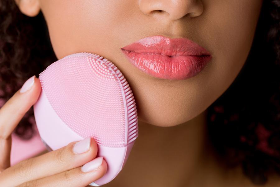 a man cleaning his face with a facial cleansing brush