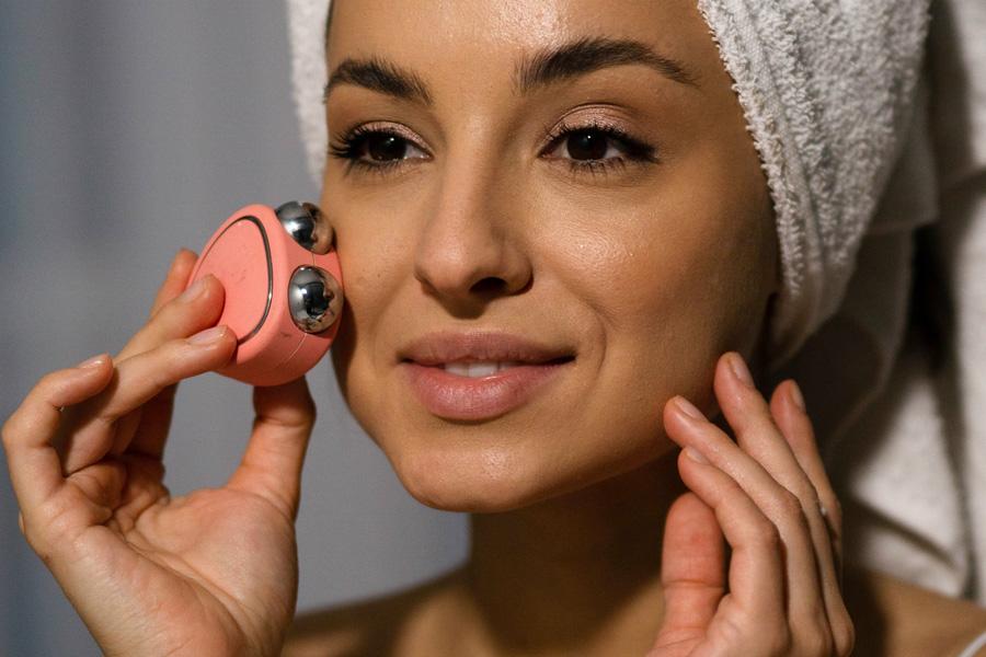 a man and a woman using a microcurrent device to tone their faces