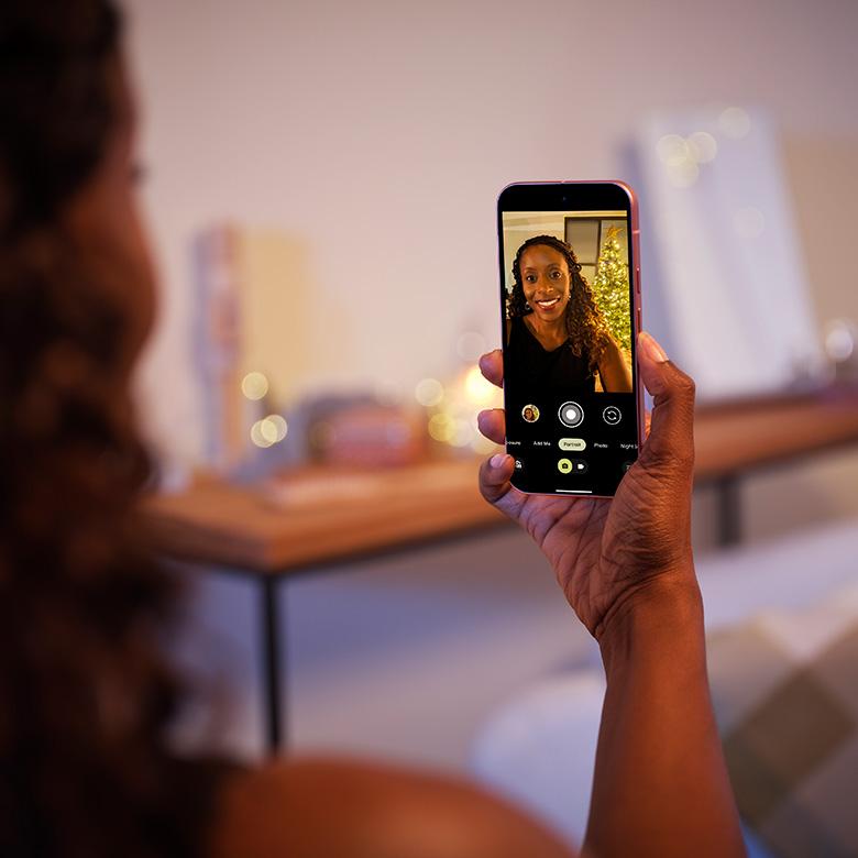 a woman holding up a google pixel 9 smartphone on a video call