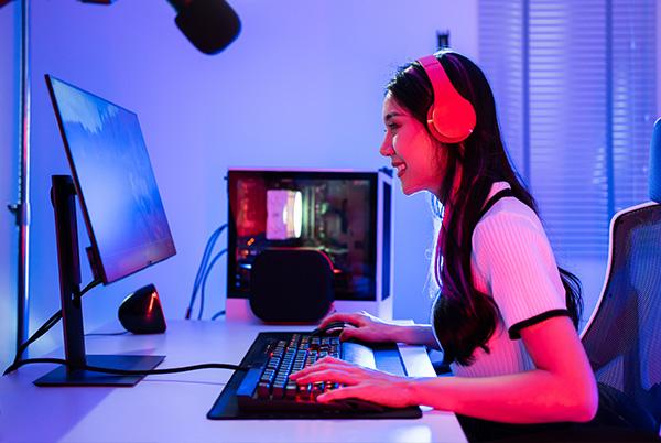 Woman at desk playing gaming monitor