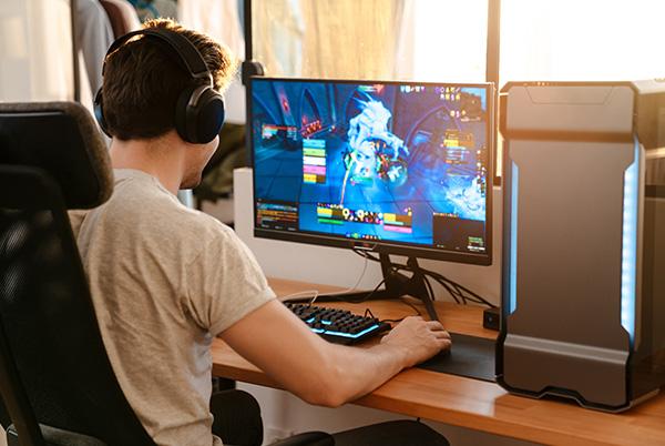 Boy gaming on desk monitor headphones