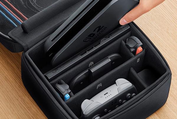 a person putting a nintendo switch 2 dock in a carrying case with their console and controller