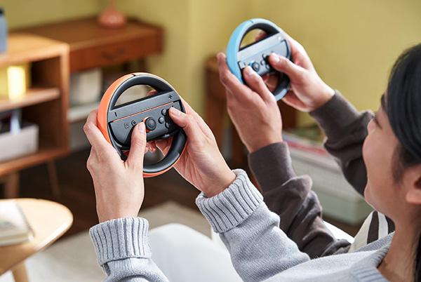 a woman and her friend holding nintendo switch 2 joy con 2 controller wheels
