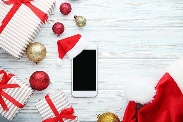 Mobile phone with Christmas hat baubles presents