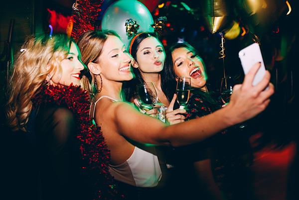 Friends taking selfie on phone at party