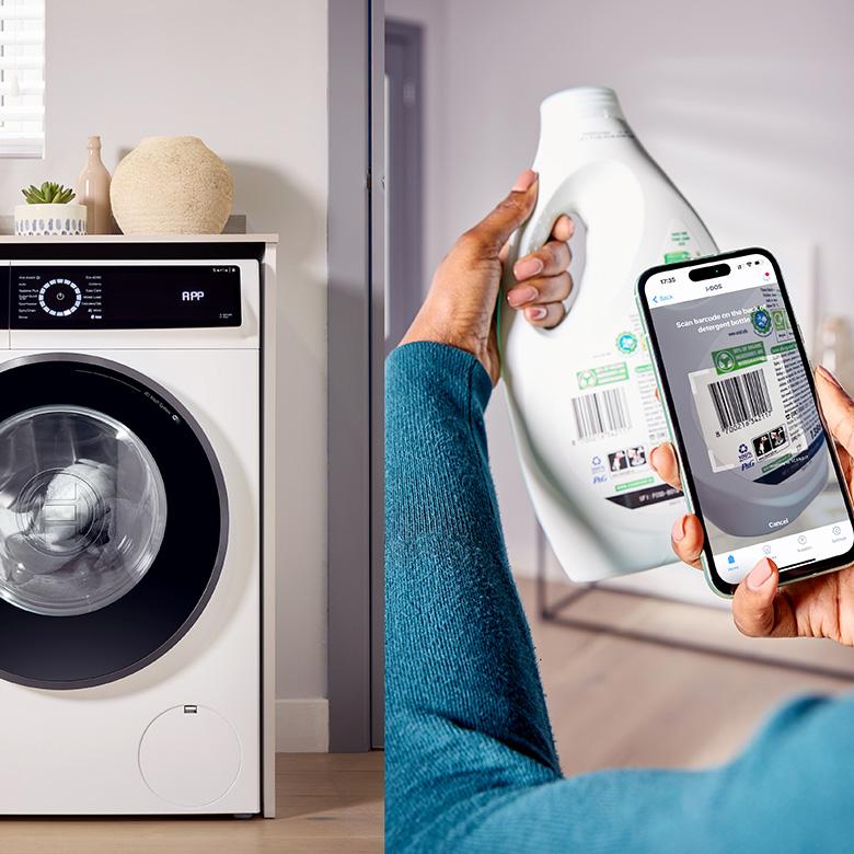 a person holding a phone next to a bosch series 8 i-dos wi-fi washing machine