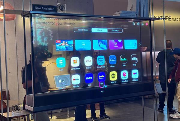 a group of people standing around a large screen with apps on it at ces 2025