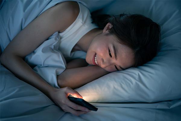 iphone woman bed screen smiling