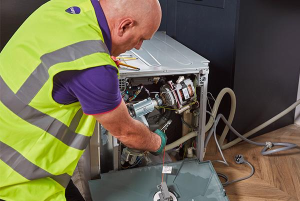 a man in a safety vest working on a broken appliance