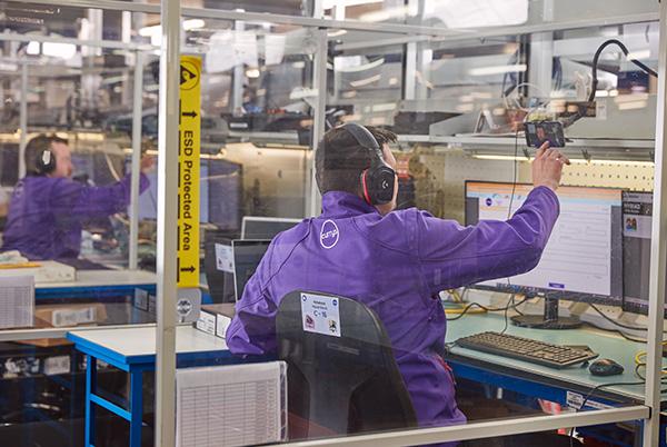 a man in a purple jacket working on a computer