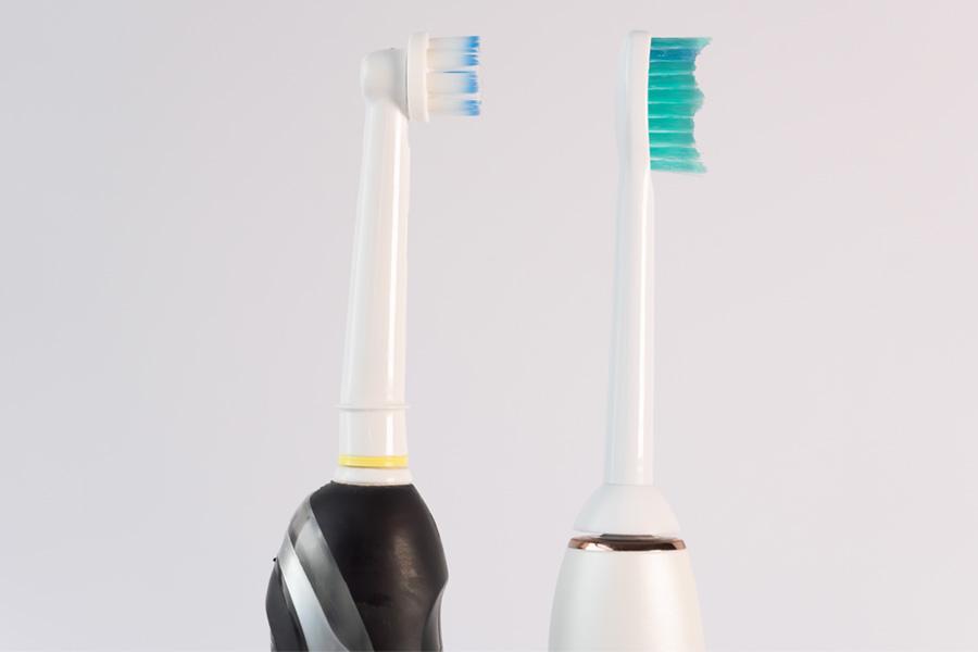 a man in glasses holding a toothbrush in his mouth