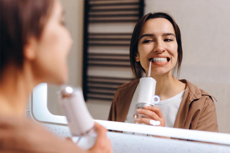 a woman brushing her teeth with a toothbrush in a bathroom