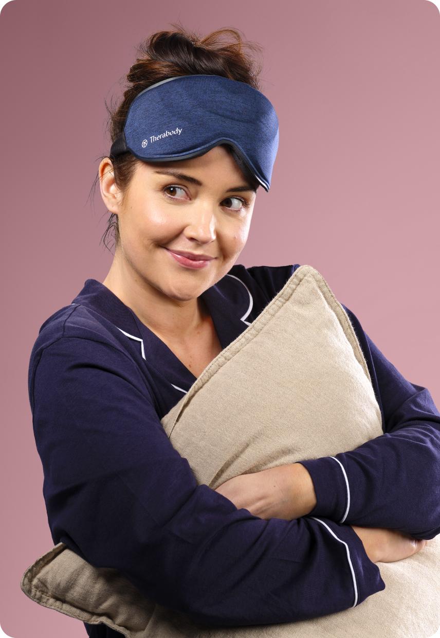 A lady on a bed with a eye mask on