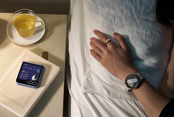a person laying in bed with a smart watch on their wrist and a smart ring on their finger