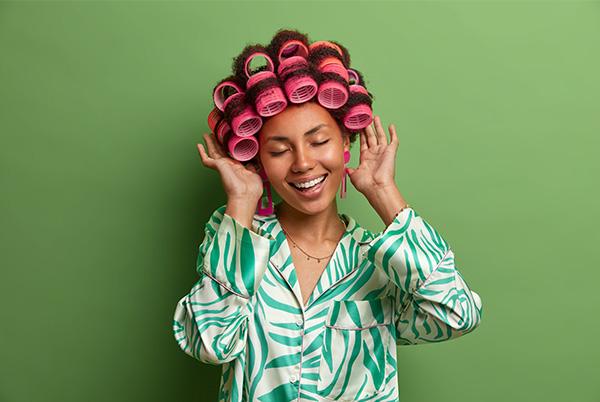 a woman with pink hair curlers on her head