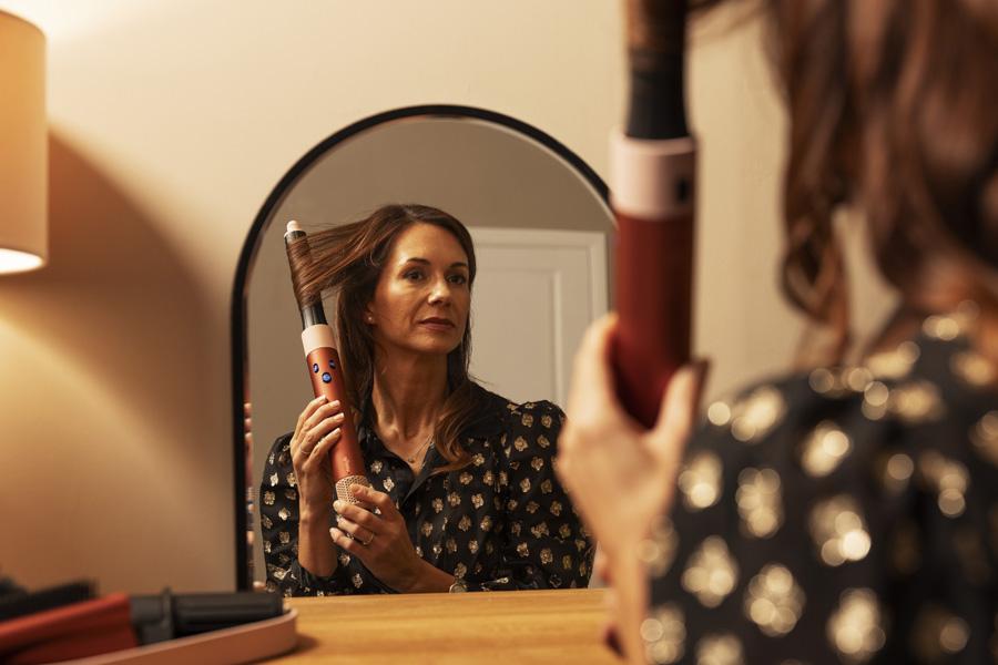 a woman is brushing her hair in front of a mirror