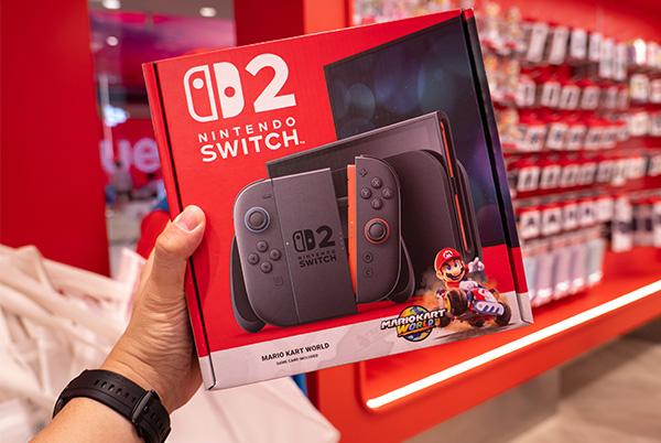 a person holding a nintendo switch 2 boxed in a store