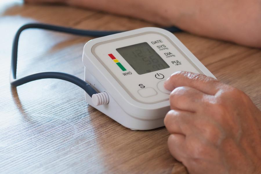 a person sitting on a couch with a blood pressure monitor