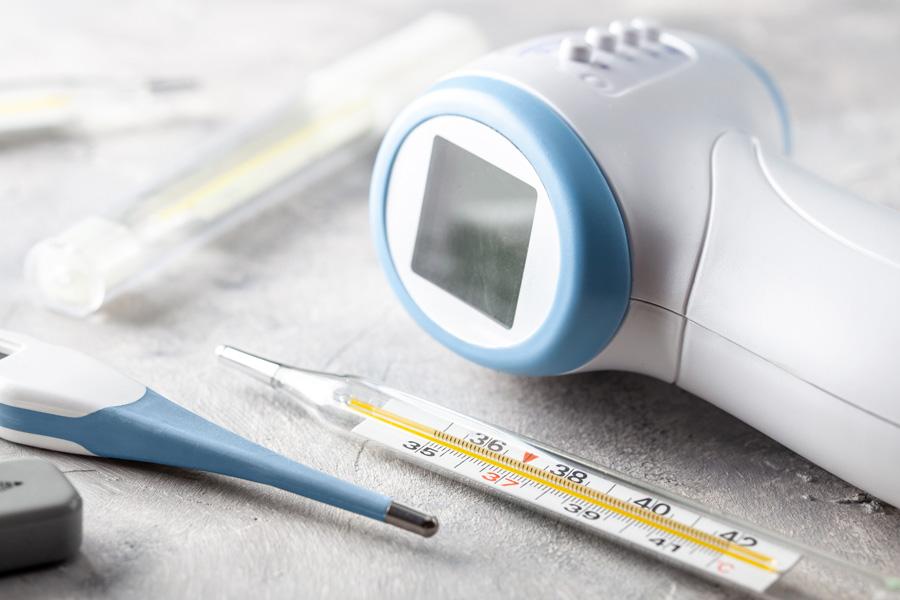 a man holding a mobile phone and a digital thermometer