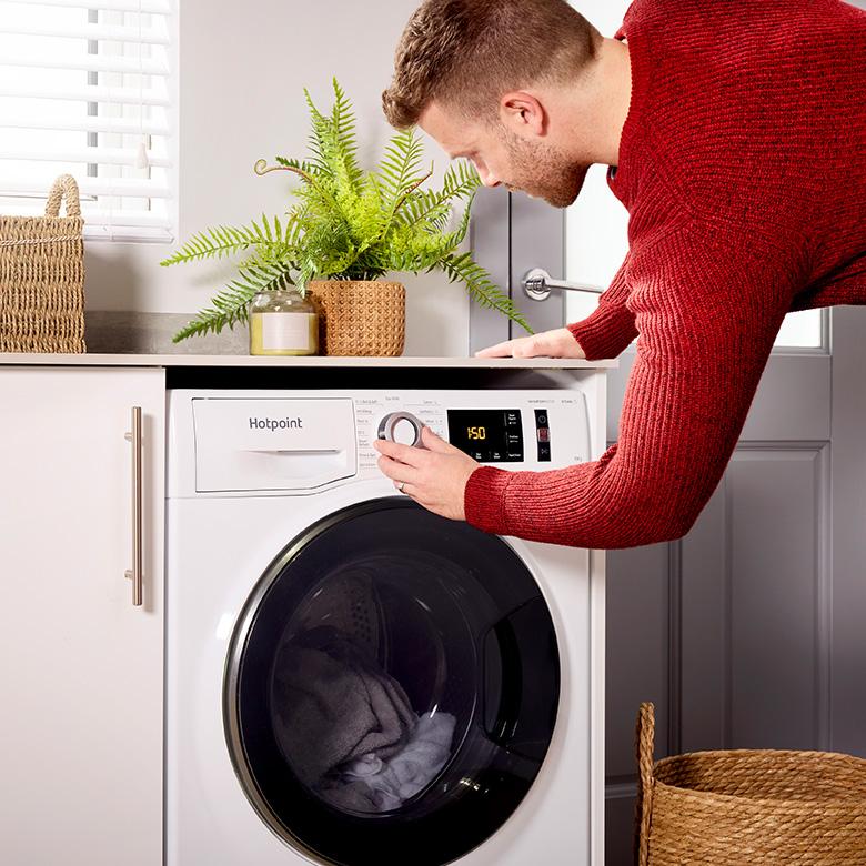 a man in red sweater adjusting hotpoint activecare nm11 washing machine door