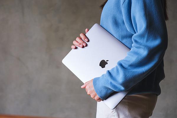 Woman holding MacBook laptop