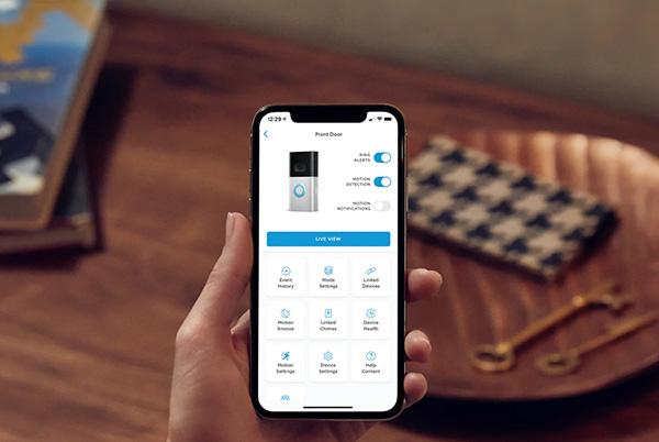 a person holding a phone in their hand with the ring app open on the screen