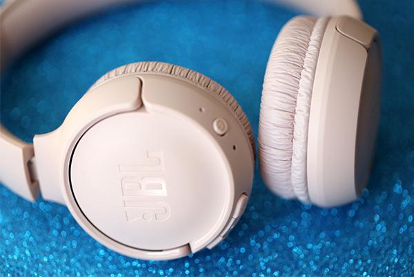 a close up of a pair of jbl headphones on a blue surface