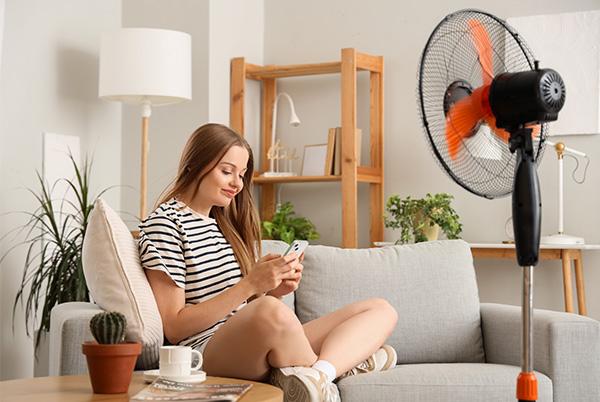 woman phone living room fan sofa