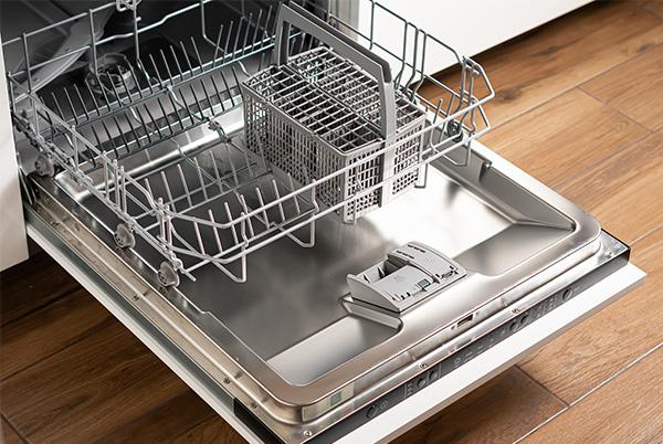 a dishwasher with a basket inside of it on a wooden floor