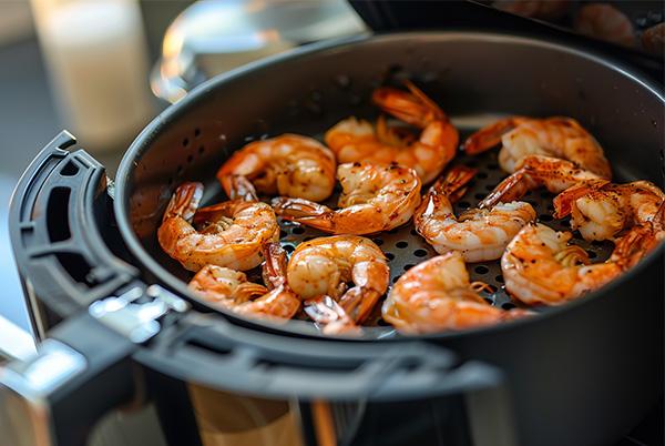 a pan filled with shrimp cooking in air fryer basket