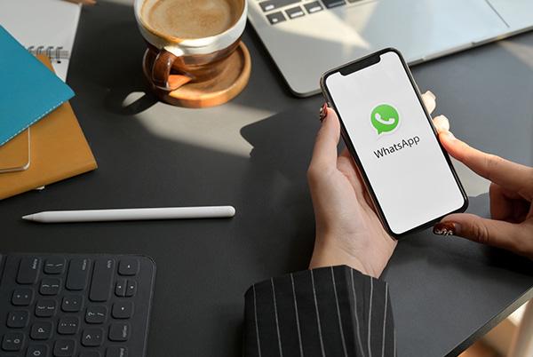 WhatsApp iPhone screen desk hands