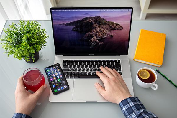 macbook iphone desk glass mug hands plant