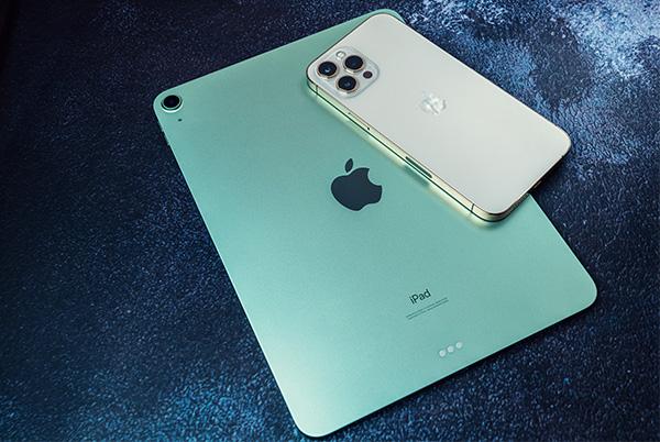 a white iphone sitting next to a green ipad
