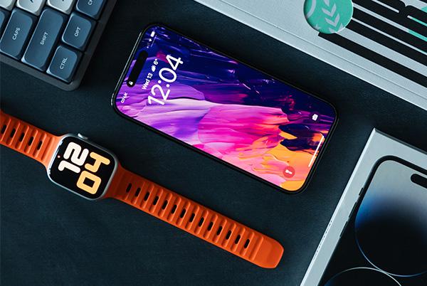 a close up of an iPhone, a keyboard, and an Apple Watch on a desk