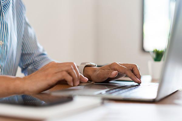 Man typing on laptop keyboard