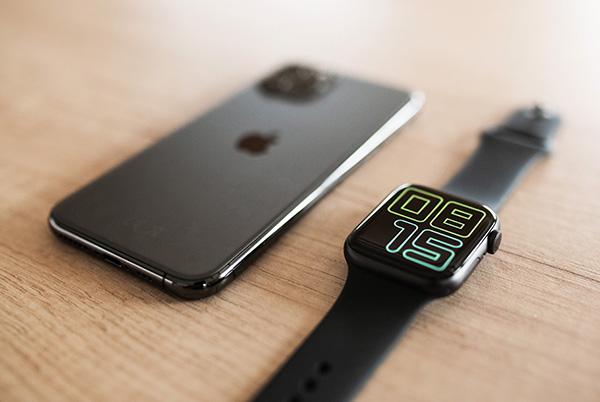 apple watch next to iphone on wooden desk