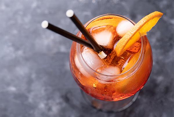aperol spritz cocktail with orange slice and straw