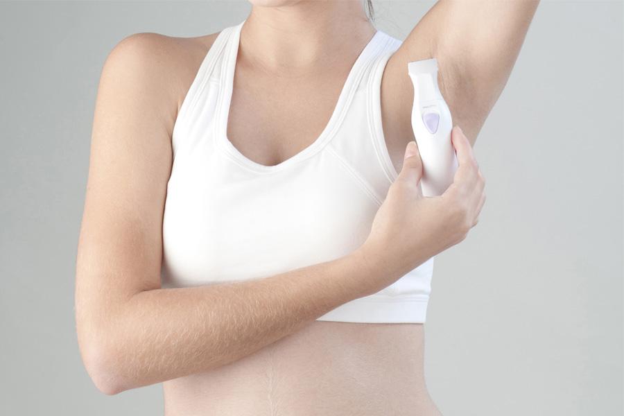 a woman with a cell phone in her hand and a brush on her face