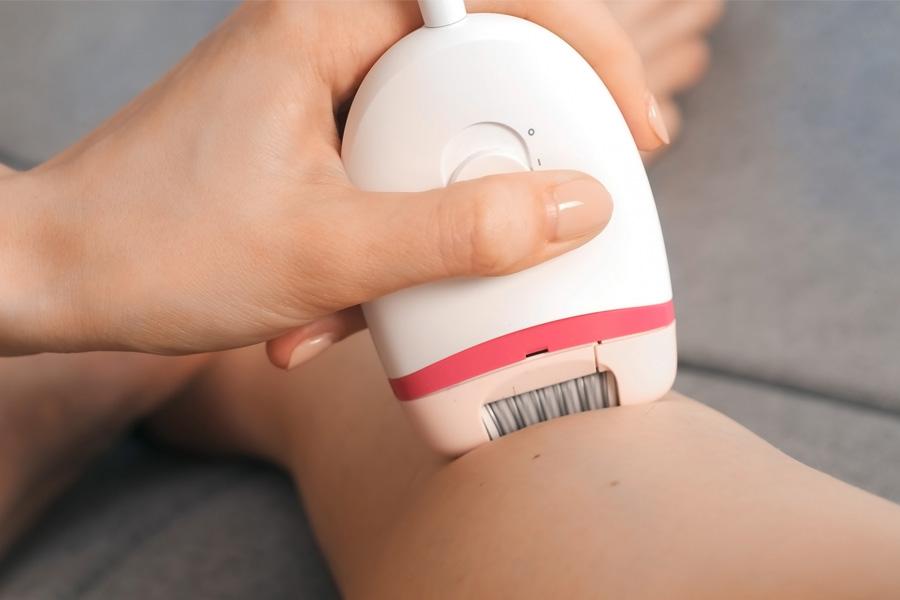 a woman is using an electronic device to remove her hair