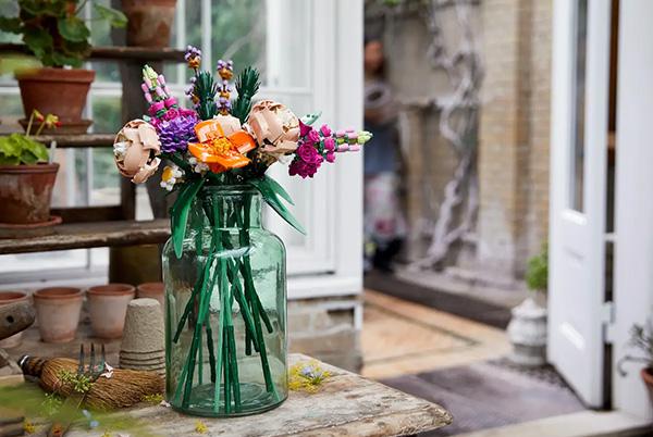 a vase of a glass jar filled with a lego botanicals flower bouquet on a table