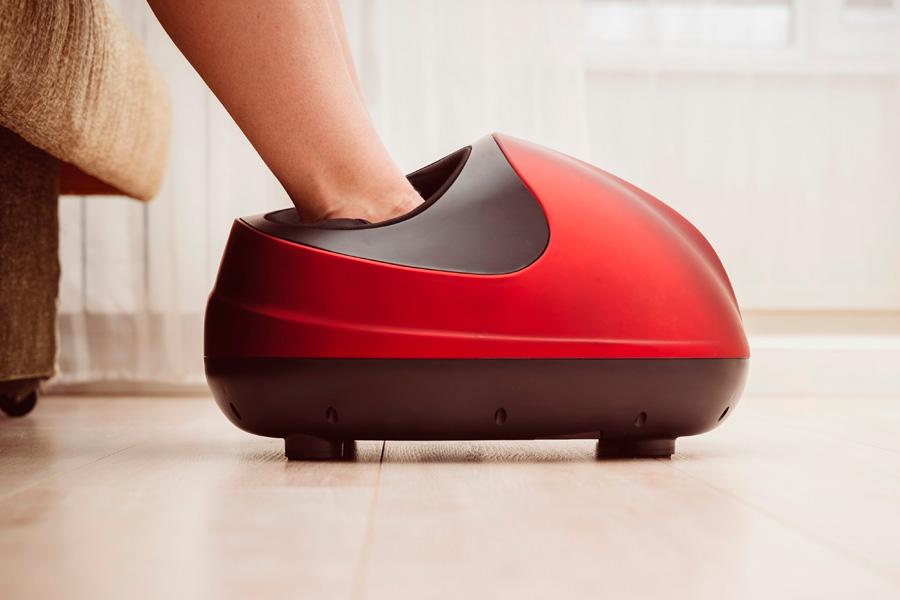 a woman sitting on a chair with a foot massager on her foot
