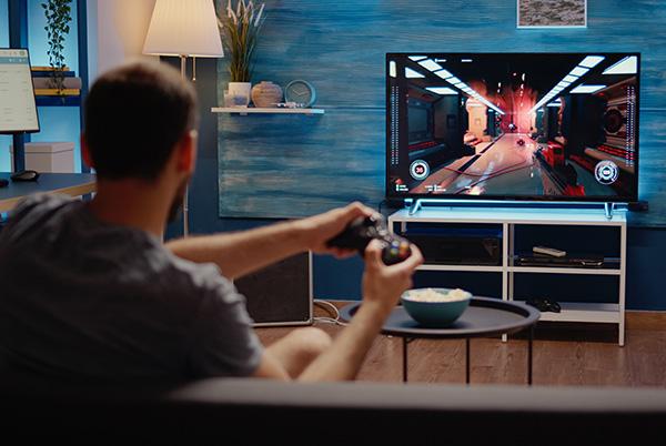 a man sitting in a chair playing a video game on a television