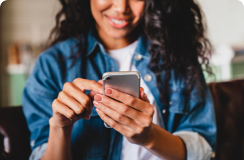 A woman holding a smart phone and smiling